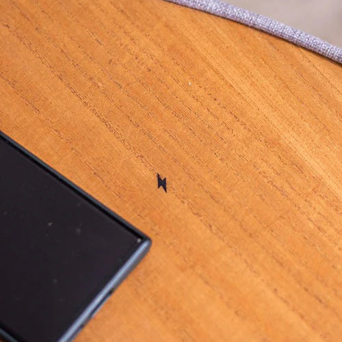 Close-up of a wooden surface with a black object on it