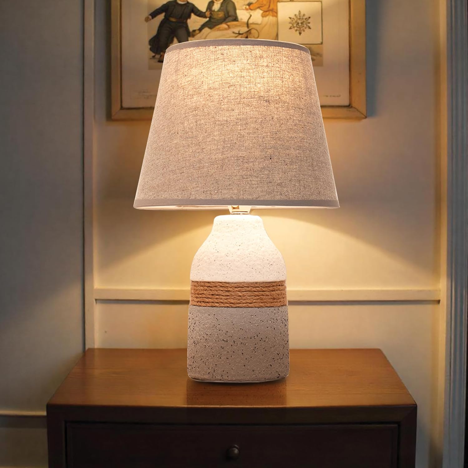 Decorative table lamp with a textured base and lampshade on a wooden surface.