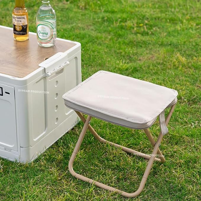 Foldable stool on grass next to a cooler with drinks